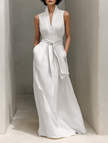Full-body image of a woman in a FJØRNA linen V-neck maxi dress, showcasing a chic, relaxed fit and lightweight fabric.