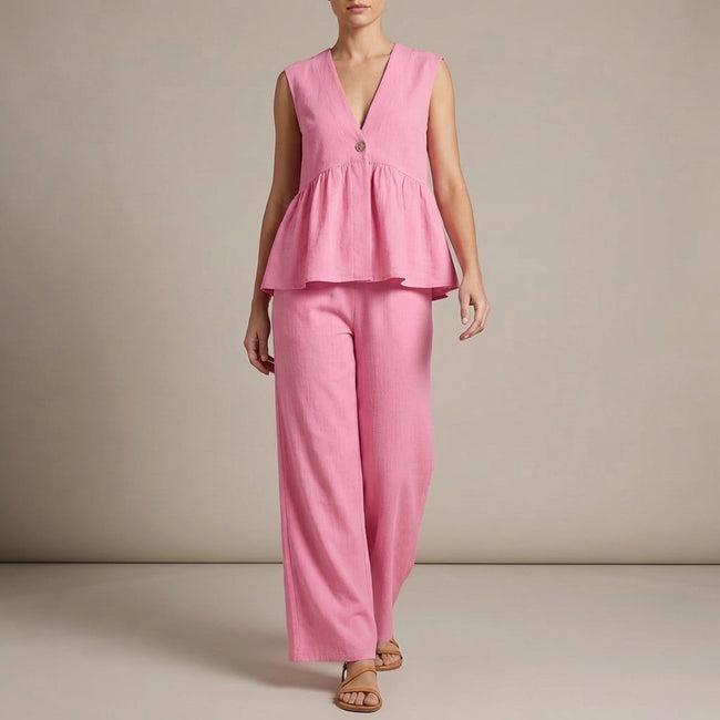 Pink FJØRNA summer two-piece women's co-ord set with wide-leg pants and V-neck top, styled for warm weather.