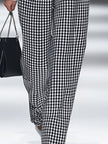 White houndstooth tailored women's straight-leg trousers from FJØRNA, shown flat with detailed fabric close-up.