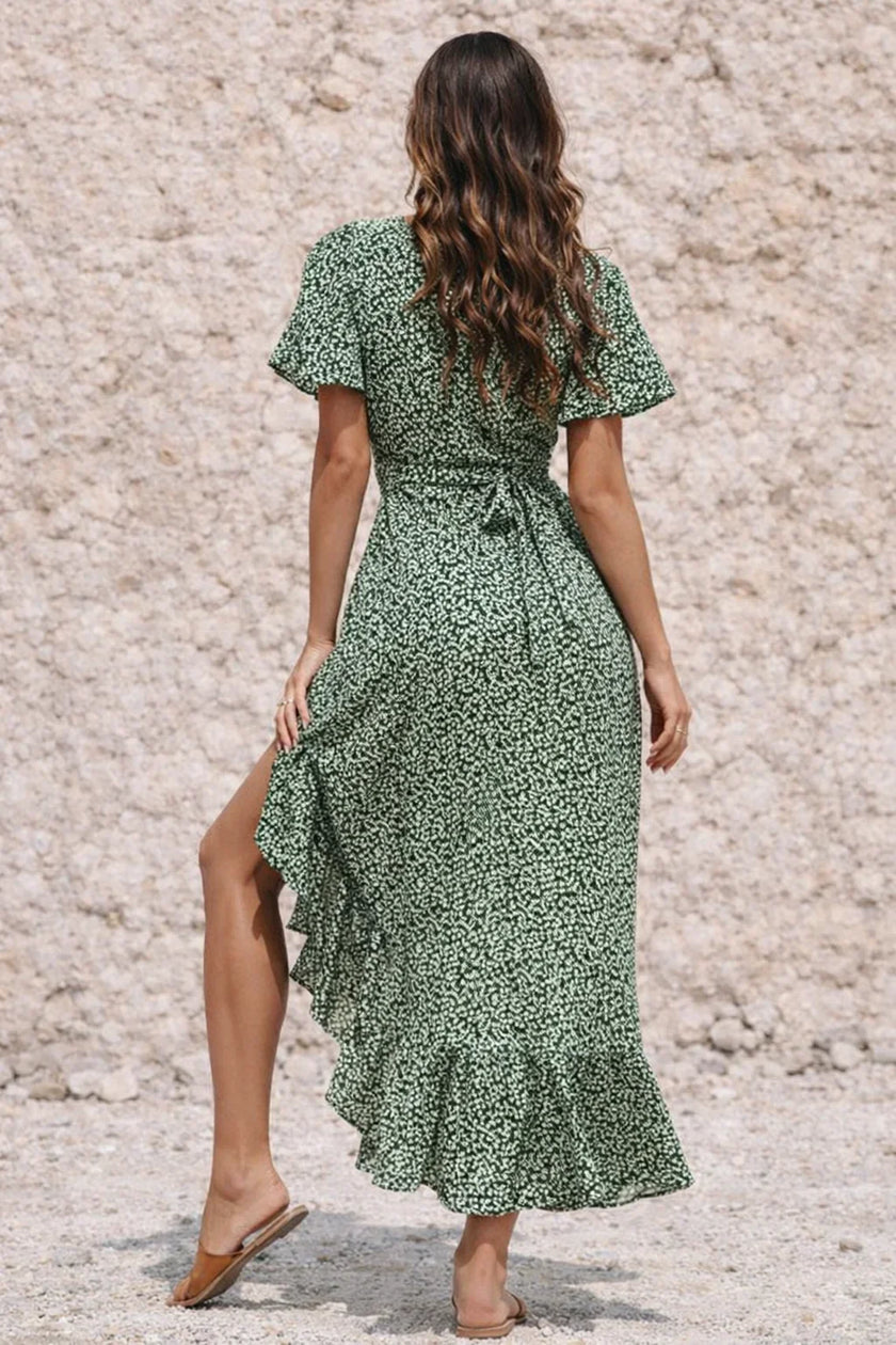 Dark sage green FJØRNA dress displayed on a mannequin, featuring a flowing silhouette and elegant design.