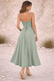 Dusty sage green FJØRNA dress with a flowing design, featuring soft fabric and elegant silhouette in the image.