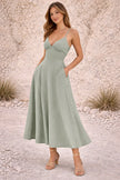 Dusty sage green FJØRNA dress featuring a flowing design and soft fabric, perfect for casual or semi-formal wear.