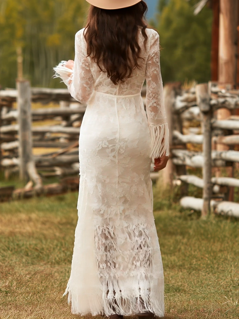 White lace V-neck maxi dress by FJØRNA featuring delicate lace details and a flowing silhouette for elegant evening wear.