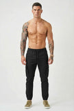 Men's black cargo jogger trousers by FJØRNA, featuring relaxed fit and multiple utility pockets, shown on a model.