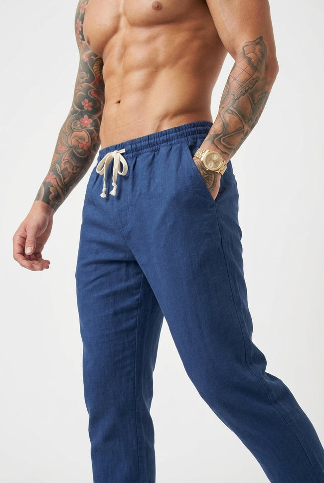 Men's linen tailored trousers by FJØRNA, featuring a slim fit design and neutral color, displayed on a model.