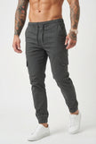 Men's grey cargo jogger trousers by FJØRNA, featuring a relaxed fit and multiple pockets, shown on a model.
