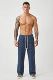 Black distressed men's trousers by FJØRNA, showing a slim fit design with ripped details and casual style.