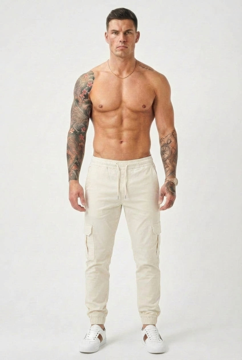 Men's FJØRNA cargo jogger trousers in cream, featuring relaxed fit, multiple pockets, and comfortable cotton fabric.