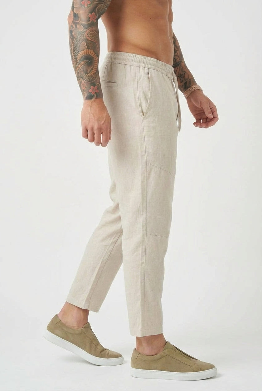 Men's cropped linen trousers in indigo by FJØRNA, showcasing relaxed fit and lightweight fabric for casual style.