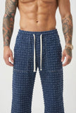 Black distressed men's trousers by FJØRNA, showcasing a stylish fit with ripped details and casual design.