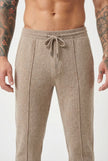 Men's beige merino wool trousers by FJØRNA, showing a close-up of stylish, comfortable wool pants with a tailored fit.