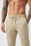 Men's beige relaxed linen trousers by FJØRNA, featuring a comfortable fit and lightweight fabric, shown on a model.