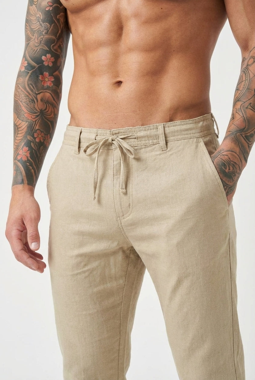 Men's beige relaxed linen trousers by FJØRNA, featuring a comfortable fit and lightweight fabric, shown on a model.