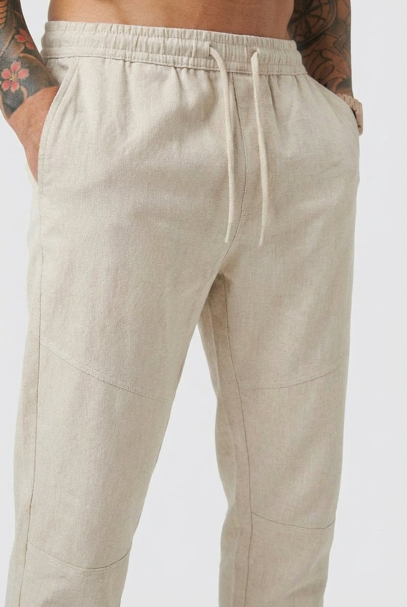 Men's cropped linen trousers in indigo by FJØRNA, shown on a model with a relaxed fit and casual style.