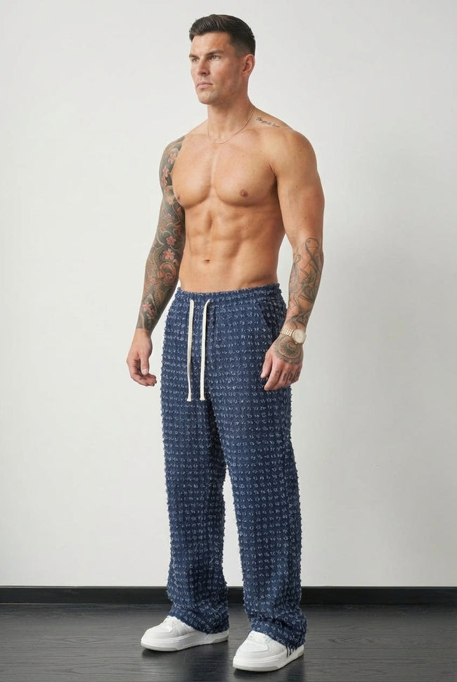FJØRNA distressed black men's trousers with a relaxed fit and stylish worn-in look, shown on a model.
