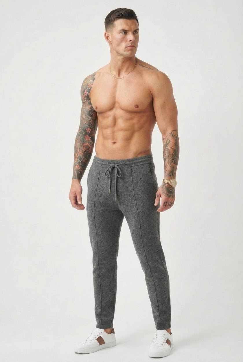 Men's merino wool trousers in dark grey by FJØRNA, showing the relaxed fit and smooth fabric detail.