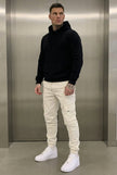 Men's cargo jogger trousers in cream by FJØRNA, featuring a relaxed fit, multiple pockets, and comfortable fabric.