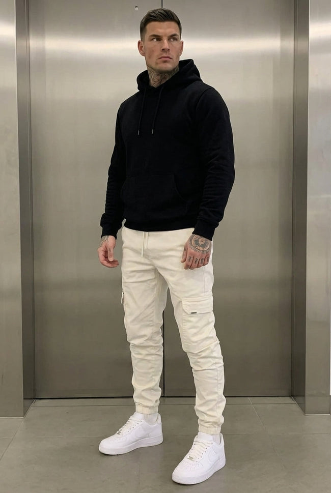 Men's cargo jogger trousers in cream by FJØRNA, featuring a relaxed fit, multiple pockets, and comfortable fabric.