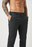 Men's black slim-fit trousers by FJØRNA, tailored fit with sleek fabric, shown on a model.