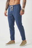 FJØRNA linen tailored men's trousers displayed flat, showing beige color, slim fit design, and classic waistband with belt loops.