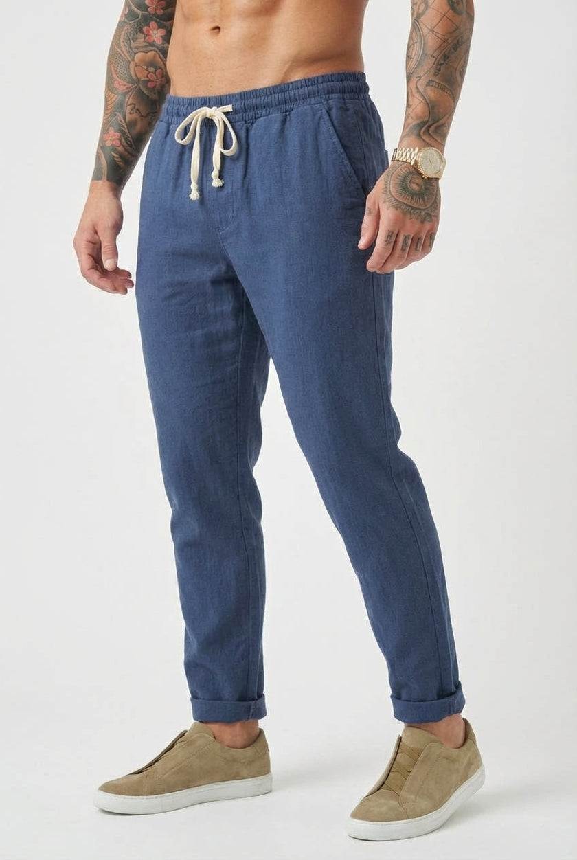 FJØRNA linen tailored men's trousers displayed flat, showing beige color, slim fit design, and classic waistband with belt loops.