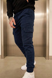 Men's navy cargo jogger trousers by FJØRNA, featuring relaxed fit and practical pockets, ideal for casual and active wear.