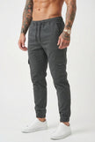 Men's grey cargo jogger trousers by FJØRNA, featuring a relaxed fit and multiple cargo pockets, shown on a model.