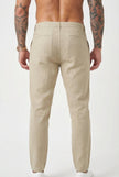 Men's relaxed beige linen trousers by FJØRNA, featuring a comfortable fit and casual style, shown on a model.