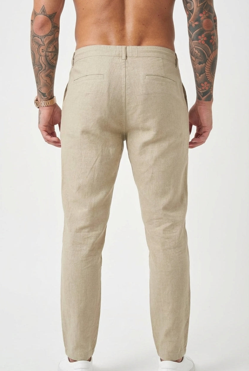Men's relaxed beige linen trousers by FJØRNA, featuring a comfortable fit and casual style, shown on a model.