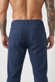 Men's linen tailored trousers by FJØRNA, featuring a slim fit design with side pockets and a neutral beige color.