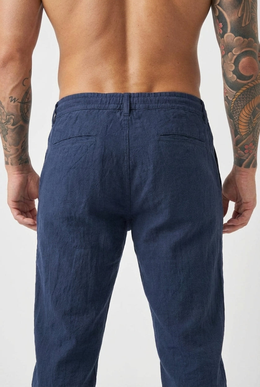Men's linen tailored trousers by FJØRNA, featuring a slim fit design with side pockets and a neutral beige color.