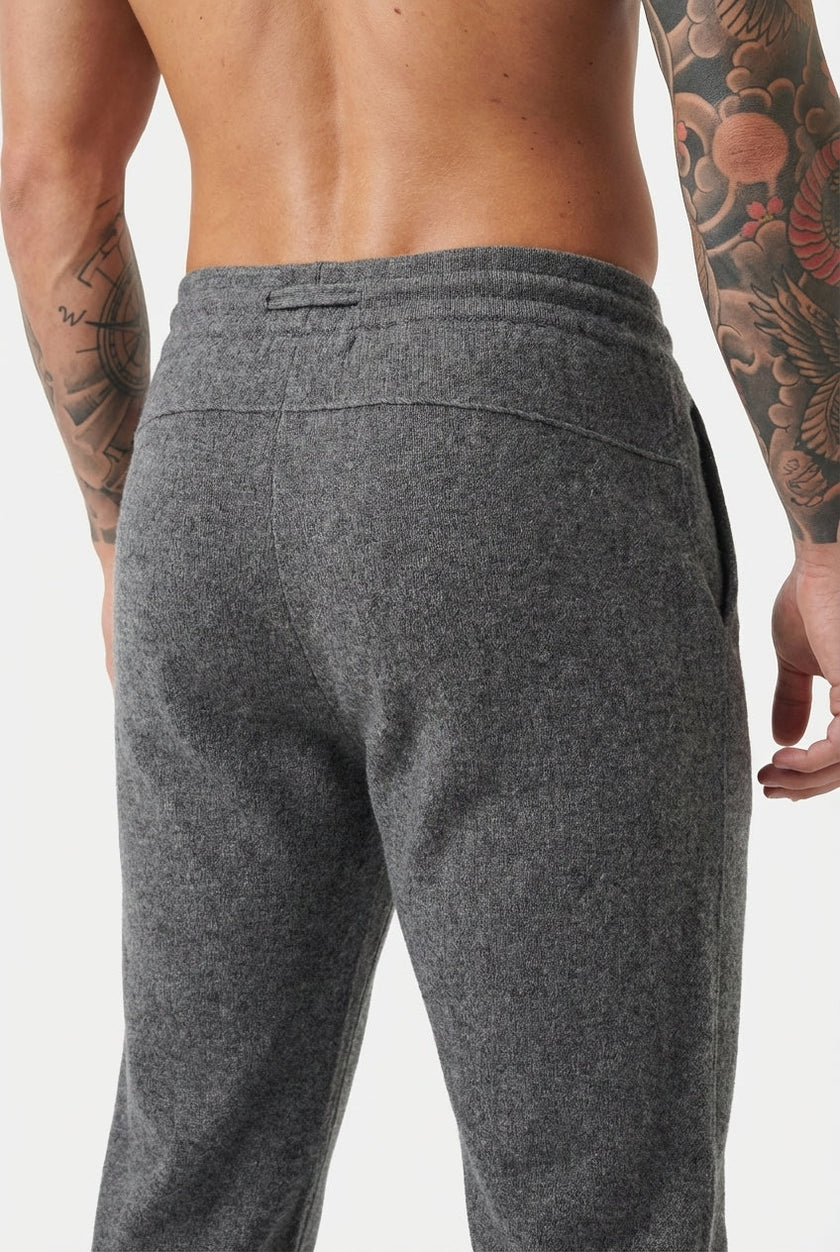 Men's dark grey merino wool trousers by FJØRNA, shown with a tailored fit and smooth fabric texture.