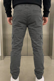 Men's grey cargo jogger trousers by FJØRNA with multiple pockets and relaxed fit, shown on a model.