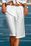 FJØRNA women's high-waist pleated Bermuda shorts in lightweight summer fabric, shown in beige on a model.
