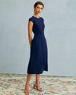 FJØRNA polka dot cutout cap-sleeve midi dress with round neckline, perfect for summer business occasions, shown on a model.