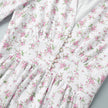FJØRNA white floral V-neck mini dress with lantern sleeves, featuring a detailed view of the elegant floral pattern.