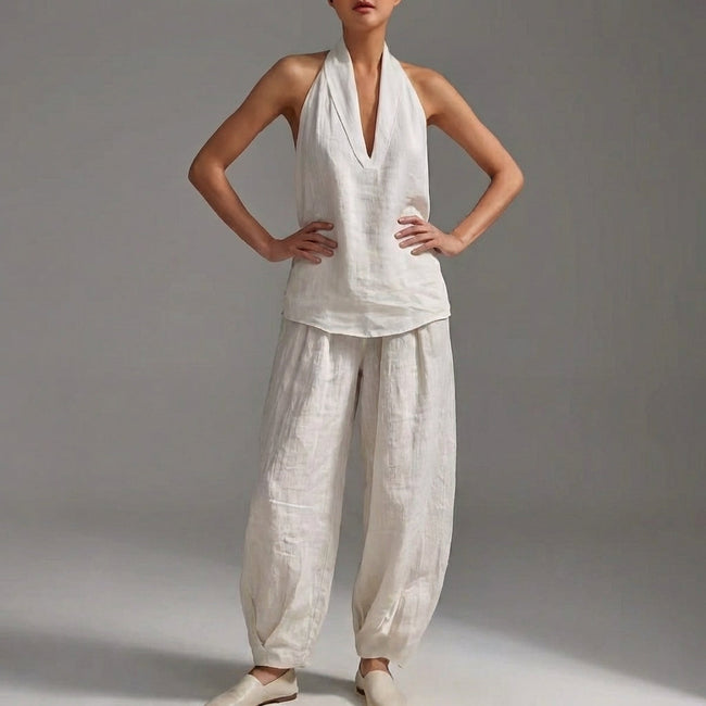 White FJØRNA women's two-piece co-ord set with V-neck top and matching pants, featuring front pockets, perfect for summer wear.