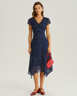 Navy polka dot chiffon V-neck midi dress by FJØRNA, perfect for wedding guests, with flowing fabric and elegant design.
