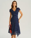Navy polka dot chiffon V-neck midi dress by FJØRNA, perfect for wedding guests, featuring a flowing woven polyester fabric.