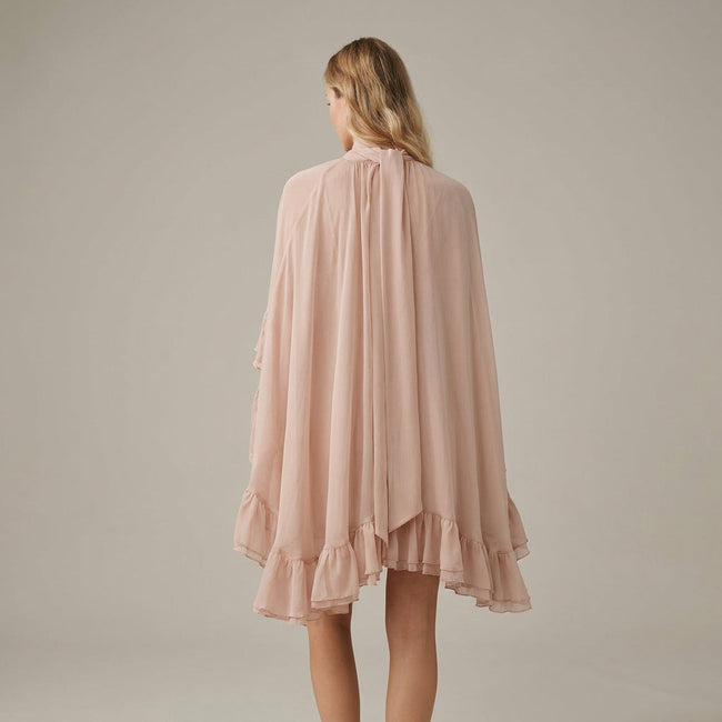 FJØRNA ruffle chiffon mini dress with high neck and layered fit, shown from the back in salmon color.