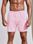 Men's striped FJØRNA swim shorts with a regular fit, featuring a colorful pattern, suitable for summer beach and pool wear.